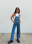 Overalls Mid wash denim  Embroidered graphic at chest  Adjustable shoulder straps Chest & leg pockets Four classic pockets  Button fastening at hips Wide leg 