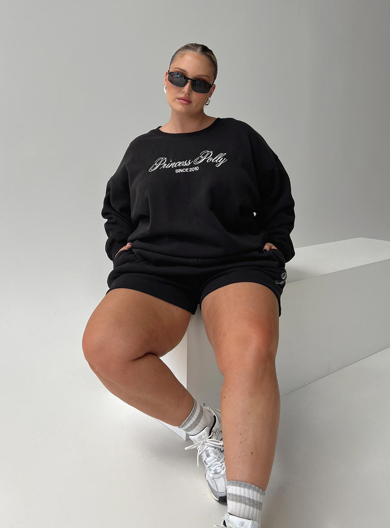 front view of model wearing Princess Polly Princess Polly Track Shorts Cursive Text Black Sand Curve High Waisted Shorts 