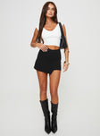 front view of model wearing Princess Polly Maceline Wrap Front Skort Black Tall High Waisted Shorts 