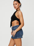   side view of model wearing Princess Polly Faya Low Rise Mini Denim Skirt Vintage Dark Wash Tall Mini Skirts 