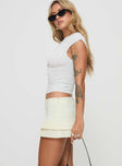 side view of model wearing Princess Polly Deei Double Ruffle Mini Skort Soft Lemon Low Rise Shorts 