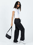 Front view of model wearing  front Princess Polly High Waisted Pants  Connels Parachute Pants Black