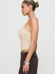 side view of model wearing Princess Polly Catalyst Asymmetrical Top Cream Sleeveless Asymmetric Neckline 