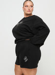 side view of model wearing Princess Polly Princess Polly Track Shorts Cursive Text Black Sand Curve High Waisted Shorts 