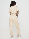 back view of model wearing Princess Polly Princess Polly Track Pants Block / Cursive Text Stone Mid Rise 