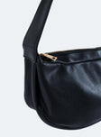 Black shoulder bag Faux leather material Adjustable shoulder strap Zip fastening  Gold toned hardware Flat base