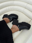 Black flats Faux leather material Closed rounded toe Silver-toned buckle detail Platform base Padded footbed