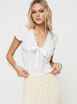 Top V-neckline, knit lace trim, tie detail at bust, button fastening at front