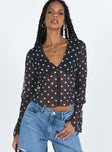 long sleeve black top Sheer material Polka dot print V-neckline Button fastening at front Waist tie fastening at back