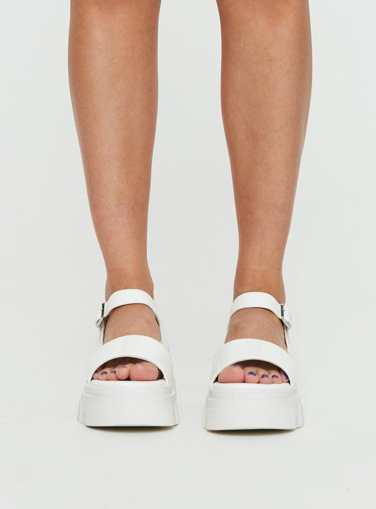 Sandals Strappy upper, faux leather, silver-toned hardware, buckle fastening, platform base,        treaded sole, rounded toe