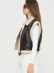 Shearling vest Faux leather, classic collar, exposed zip fastening, belt looped waist, twin pockets with zip closure Non-stretch material, shearling lining