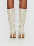 Cream Knee-high boots Faux leather material, zip fastening at inside, pointed toe, stiletto heel